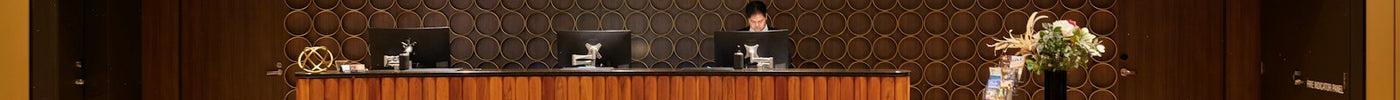 Modern hotel reception desk with wooden furniture and lounge seating