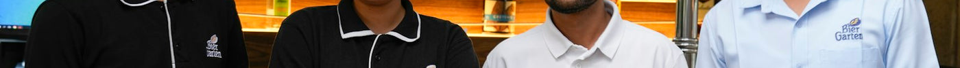 Four smiling hospitality staff members standing in front of a bar