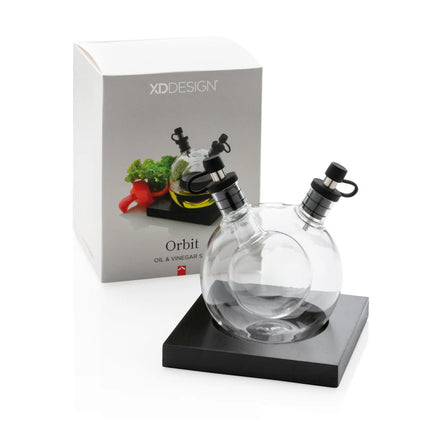 XD Design Orbit oil and vinegar set with clear glass bottles and stainless steel pour spouts for kitchen use.