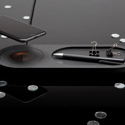  black accessory with charging pad and space for devices.