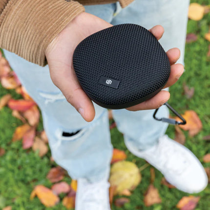 Urban Vitamin IPX7 waterproof 5W audio speaker shown in black with a cylindrical design and control buttons on top.