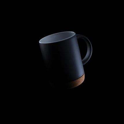  white mug with natural cork bottom on a wooden surface.