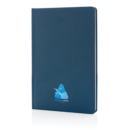 A5 Impact stone paper hardcover notebook from XD Collection with a sleek black cover and a pen resting on top.