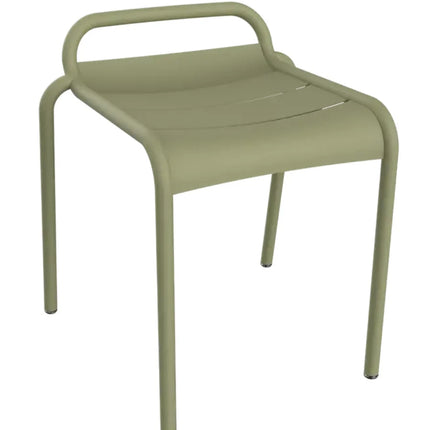 White Fermob Luxembourg outdoor dining stool shown in a modern outdoor setting with a sleek