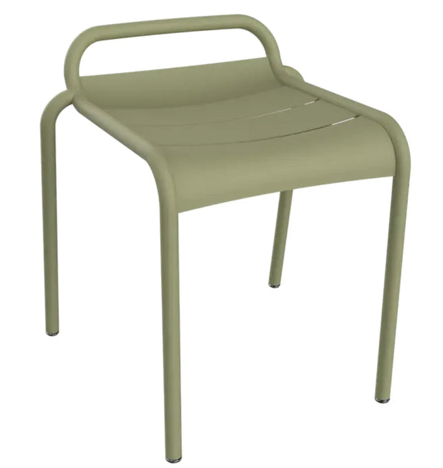 White Fermob Luxembourg outdoor dining stool shown in a modern outdoor setting with a sleek