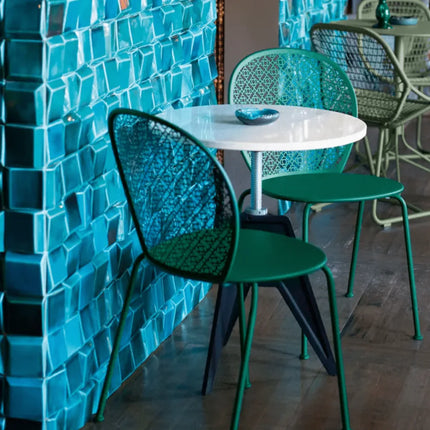 Clay grey Fermob Lorette outdoor metal chair with a curved back and slim legs