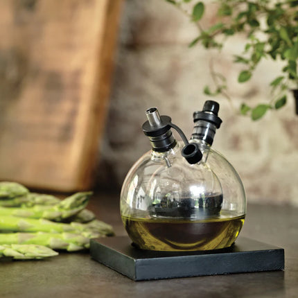 XD Design Orbit oil and vinegar set with glass bottles and stainless steel pour spouts for kitchen use.